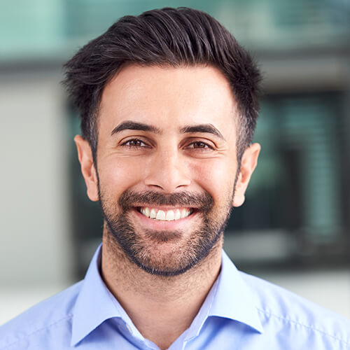 portrait of smiling businessman standing in lobby 3QPCMXE